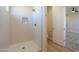 Modern shower with niche and glass door in bathroom with wood look flooring at 57856 W Fulcar Rd, Maricopa, AZ 85139