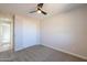 Bright bedroom featuring neutral carpet, a ceiling fan, and a closet at 57856 W Fulcar Rd, Maricopa, AZ 85139