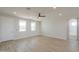 Spacious bedroom with natural light, wood-look flooring, and ensuite bathroom at 57856 W Fulcar Rd, Maricopa, AZ 85139
