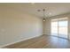 Bright dining area next to the kitchen with modern light fixture and sliding glass door at 57856 W Fulcar Rd, Maricopa, AZ 85139