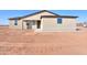 Neutral colored single Gathering home featuring a dark front door, minimal landscaping, and dual paned windows at 57856 W Fulcar Rd, Maricopa, AZ 85139