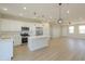 Stylish kitchen with stainless appliances, a spacious island, and open to the living area at 57856 W Fulcar Rd, Maricopa, AZ 85139