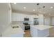 Modern kitchen with white cabinets, stainless steel appliances and a center island at 57856 W Fulcar Rd, Maricopa, AZ 85139