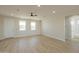 Spacious living room with wood-look flooring, a ceiling fan, recessed lighting and large windows at 57856 W Fulcar Rd, Maricopa, AZ 85139