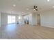 Open-concept kitchen and living area filled with natural light and wood-look floors at 57856 W Fulcar Rd, Maricopa, AZ 85139