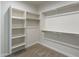 Bright walk-in closet features neutral carpet, white walls, shelves and metal closet rods for ample storage space at 57856 W Fulcar Rd, Maricopa, AZ 85139
