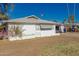 Side view of a white single-story home featuring a white roof and well-kept landscaping at 638 W 16Th St, Tempe, AZ 85281