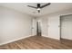 Bedroom featuring a ceiling fan, closet and en suite entrances, and wood-look floors at 6926 E Moreland St, Scottsdale, AZ 85257