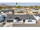 Single-story home with a black roof, covered front porch and desert landscaping at 7014 E Latham St, Scottsdale, AZ 85257