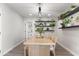 Bright dining area with wood table, bench seating, floating shelves, and modern lighting at 7014 E Latham St, Scottsdale, AZ 85257