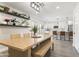 Open-concept dining area with wood table, bench seating, and view of the modern kitchen at 7014 E Latham St, Scottsdale, AZ 85257