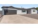 Beautiful one-story house showcasing a black garage door, black trim, and rock landscaping at 7014 E Latham St, Scottsdale, AZ 85257