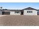 Charming single-story home featuring a well-maintained exterior, black trim, and low maintenance desert landscaping at 7014 E Latham St, Scottsdale, AZ 85257