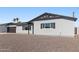 A view of a one-story house with a black garage door, black trim, and rock landscaping at 7014 E Latham St, Scottsdale, AZ 85257