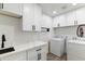 Well-organized laundry room with white cabinetry, quartz counters, and modern appliances at 7014 E Latham St, Scottsdale, AZ 85257