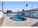 Backyard pool with brick patio, privacy wall, and lush green landscaping at 7014 E Latham St, Scottsdale, AZ 85257