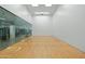 Modern squash court with glass wall, hardwood floors, and clear court markings at 7137 E Rancho Vista Dr # 5001, Scottsdale, AZ 85251