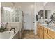 Bathroom featuring a soaking tub, glass block shower, wood cabinets, and a granite countertop vanity at 7223 W Saddlehorn Rd, Peoria, AZ 85383