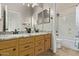 Updated bathroom with double sinks, granite countertops, and a shower over the tub at 7223 W Saddlehorn Rd, Peoria, AZ 85383