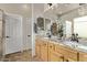 Bathroom showcasing a double vanity, granite countertops, light-colored wood cabinets, and modern fixtures at 7223 W Saddlehorn Rd, Peoria, AZ 85383