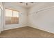 Clean bedroom with neutral walls, carpeted floor, floating shelves, ceiling fan, and a window with blinds at 7223 W Saddlehorn Rd, Peoria, AZ 85383