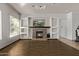 Inviting living room featuring a cozy fireplace, built-in shelving, wood-look tile flooring, and a large window at 7223 W Saddlehorn Rd, Peoria, AZ 85383
