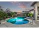 Sparkling swimming pool with Baja shelf, surrounded by lush landscaping and elegant hardscaping at 7223 W Saddlehorn Rd, Peoria, AZ 85383