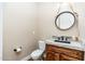 Stylish powder room features granite countertop, wood vanity, and decorative mirror at 7738 N 185Th Ave, Waddell, AZ 85355