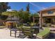This backyard patio features comfortable seating around a fire pit, a built-in bar, and a lush green space at 8373 S Forest Ave, Tempe, AZ 85284