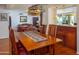 Open dining area with hardwood floors and an elegant light fixture, adjacent to the living room at 8373 S Forest Ave, Tempe, AZ 85284