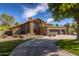 Charming home featuring a stone facade, a circular driveway, and a three-car garage at 8373 S Forest Ave, Tempe, AZ 85284