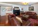 Warm living room featuring hardwood floors and leather furniture, fireplace and built-in bookshelves at 8373 S Forest Ave, Tempe, AZ 85284