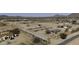 Aerial view of a horse property featuring covered stalls, a central building, and surrounding desert landscape at 9066 N Thunderbird Rd, Maricopa, AZ 85139
