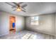 Bright bedroom with wood-look floors, ceiling fan, window and attached bath/shower area at 9066 N Thunderbird Rd, Maricopa, AZ 85139