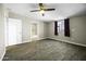 Bright bedroom features wood-look tile floors, window with blackout curtains, ceiling fan, and closet access at 9066 N Thunderbird Rd, Maricopa, AZ 85139