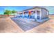 A single-story home featuring a red front door, blue trim, and a cozy front porch with two chairs at 9066 N Thunderbird Rd, Maricopa, AZ 85139