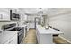 Modern kitchen boasts stainless appliances, white cabinets, stylish lighting, and island with bar stools at 9066 N Thunderbird Rd, Maricopa, AZ 85139