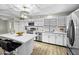 A well-lit kitchen with white cabinets, stainless steel appliances, and island seating for modern living at 9066 N Thunderbird Rd, Maricopa, AZ 85139