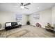 Inviting living room with wood-look floors, black futon, and bright windows at 9066 N Thunderbird Rd, Maricopa, AZ 85139