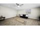 Comfortable living room with wood-look floors, a black futon, and natural light at 9066 N Thunderbird Rd, Maricopa, AZ 85139