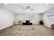 Bright living room with wood-look flooring, natural light, and a black futon at 9066 N Thunderbird Rd, Maricopa, AZ 85139