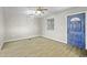 Cozy living room with a blue front door, wood-look flooring, and modern ceiling fan at 9066 N Thunderbird Rd, Maricopa, AZ 85139
