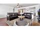 A cozy living room featuring a ceiling fan, dark leather sofas, and an open floor plan to the kitchen and dining area at 934 S Roslyn Pl, Mesa, AZ 85208