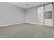 Cozy bedroom features a sliding barn door, neutral carpet and paint at 9646 E Tahoe Cir, Mesa, AZ 85212