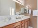 Well-lit bathroom featuring a double sink vanity, a large mirror, and coordinated towel racks at 1225 N 36Th St # 2091, Phoenix, AZ 85008