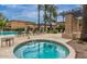 Community hot tub surrounded by lounge chairs and lush palm trees under a blue sky at 1225 N 36Th St # 2091, Phoenix, AZ 85008