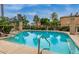 Community pool surrounded by lush landscaping, lounge chairs, and shade structures at 1225 N 36Th St # 2091, Phoenix, AZ 85008