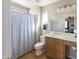 Clean bathroom features a single sink vanity, shower with curtain, and wood-look flooring at 1349 E Dunbar Dr, Phoenix, AZ 85042