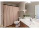 Neutral-toned bathroom featuring a single sink vanity, a striped shower curtain, and wood flooring at 1349 E Dunbar Dr, Phoenix, AZ 85042