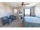 Cozy bedroom featuring soft blue tones, a ceiling fan, two armchairs, and ample natural light at 1349 E Dunbar Dr, Phoenix, AZ 85042